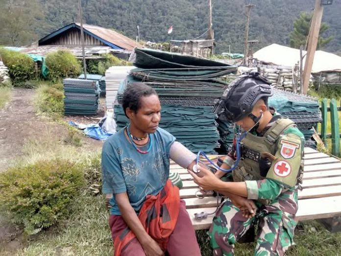 FOTO: Personil Satgas Yonif 700/Wira Yudha Cakti (WYC) menggelar kegiatan pelayanan kesehatan gratis yang dilaksanakan langsung di depan Titik Kuat Dambet, Distrik Beoga, Kabupaten Puncak, Papua.(17/04). (Properti Puspen TNI)