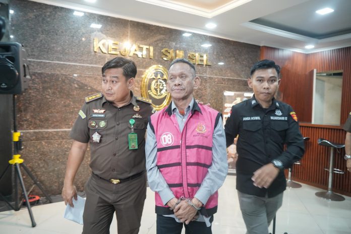 IMG-20250408-WA0189 FOTO: Kepala Seksi Penerangan Hukum (Kasi Penkum) Kejati Sulsel, Soetarmi saat membawa Direktur Utama PT. Karaga Indonusa Pratama, TGS saat akan dibawa ke mobil tahanan. Selasa (8/4/2025).