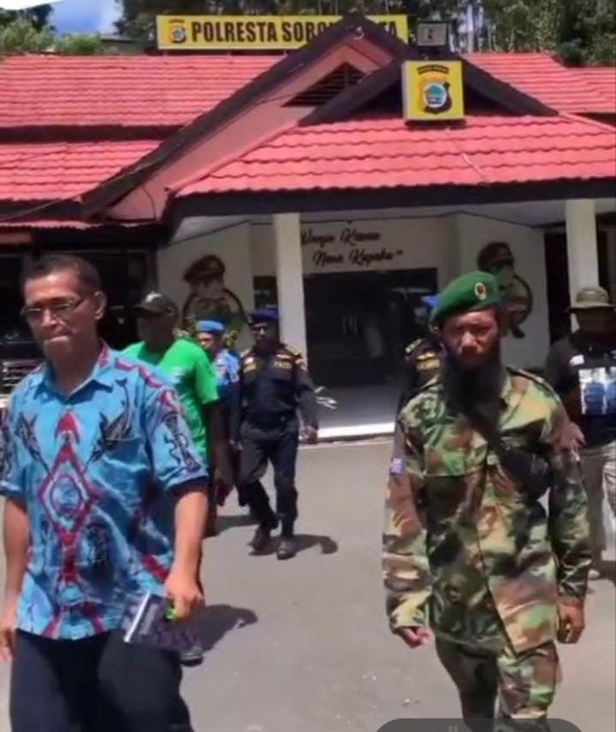 IMG-20250425-WA0018 FOTO: Tangkap layar seorang pria berbaju batik khas Papua warna biru mengaku sebagai staf khusus presiden Benny Wenda saat dikawal oleh Tentara dan Polisi NRFPB. (Sumber video viral di tiktok)