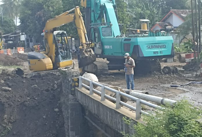 IMG_20250620_144452 FOTO: Pekerja proyek penggantian jembatan di Desa Besuk, Kecamatan Klabang, Kabupaten Bondowoso oleh CV Shasmecka Jaya tidak mematuhi standar penggunaan Alat Pelindung Diri (APD) secara memadai. (Properti LN)