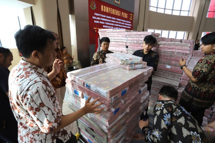 kejagung-sita-11-triliun-lebih-terkait-korupsi-ekspor-cpo4-17062025-162428 FOTO: Petugas merapikan barang bukti uang sitaan saat konferensi pers kasus korupsi ekspor crude palm oil (CPO) di Gedung Bundar Jampidus Kejaksaaan Agung (Kejagung), Jakarta, Selasa (17/6/2025). (Beritanasional.com/Oke Atmaja)