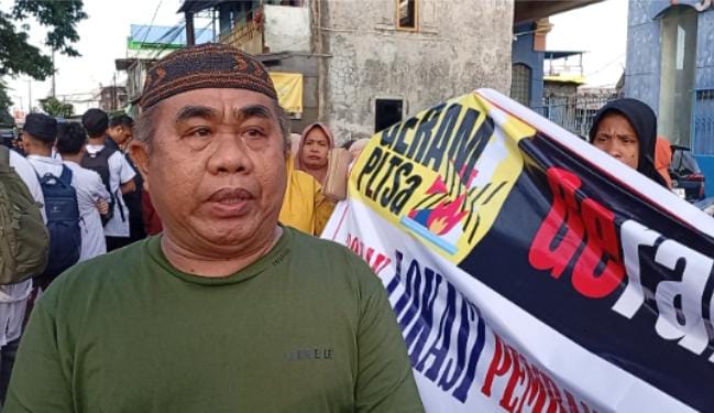 FOTO: H. Azis Tokoh Masyarakat Kelurahan Mula Baru dan Kampung Tammalalang di Kecamatan Tamalanrea saat bersama warga mendatangi gudang grand enterno di jalan Ir Soetami, Makassar, Selasa sore (29/7).