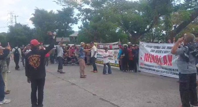 IMG-20250819-WA0379 FOTO: Warga Tamalanrea menggelar aksi unjuk rasa di depan kantor PT Parangloe Indah (FKS LAND) yang terletak di Jalan Kapasa Raya atau Jalan Jalur Lingkaran Barat, Tamalanrea, Kota Makassar, Sulawesi Selatan. Selasa (19/8). (Istimewa)