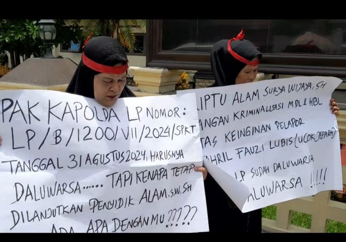 FOTO: Emak-emak yang mengaku jadi korban kriminalisasi membawa sejumlah poster di depan Mapolrestabes Medan, Rabu (3/9)
