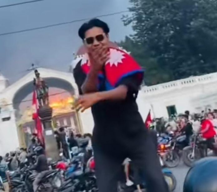 FOTO: Hasil tangkapan layar dari video di aplikasi Tiktok saat seorang anak muda melakukan aksi joget pacu jalur dengan latar belakang gedung DPR Nepal yang mengalami kebakaran.