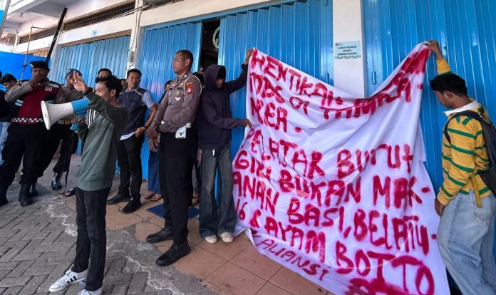 IMG-20250925-WA0439 FOTO: Aliansi Masyarakat Tamalanrea dan KAPAK 21 saat menggelar aksi unjuk rasa di dapur Satuan Pelayanan Pemenuhan Gizi (SPPG) bertempat di ruko insignia jalan Bumi Tamalanrea Permai No B26, Kelurahan Buntusu, Kecamatan Tamalanrea, Kota Makassar. Kamis siang (25/9)