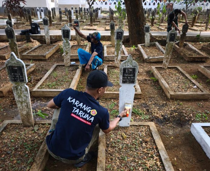 FOTO: Kader Karang Taruna melaksanakan kegiatan bakti sosial dengan melakukan pengecetan di nisan TMP Panaikang. Jumat sore (3/10)