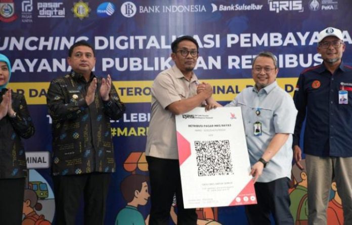 FOTO: Kiri Wali Kota Makassar, Dirut PD Pasar dan meluncurkan program Digitalisasi Pembayaran Layanan Publik dan Retribusi dengan sistem QRIS di Pasar Niaga Daya, Senin (28/7). (Properti via Fajar.co.id)