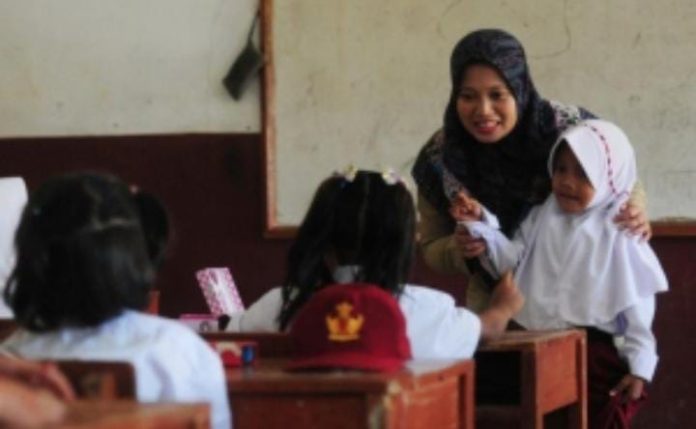 FOTO: Seorang Guru sedang mengajar di depan kelas. (Properti: Republika.com)