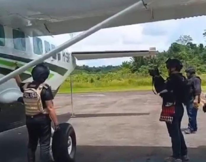 FOTO: Aparat kepolisian saat melakukan olah TKP atas penembakan pesawat Smart Air PK-SNR di Kabupaten Boven Digoel, Papua Selatan. (Dok. Antara via Facebook)