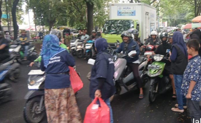 FOTO: Pengurus dan Kader Partai Nasdem Kota Makassar saat membagi takjil kepada warga.