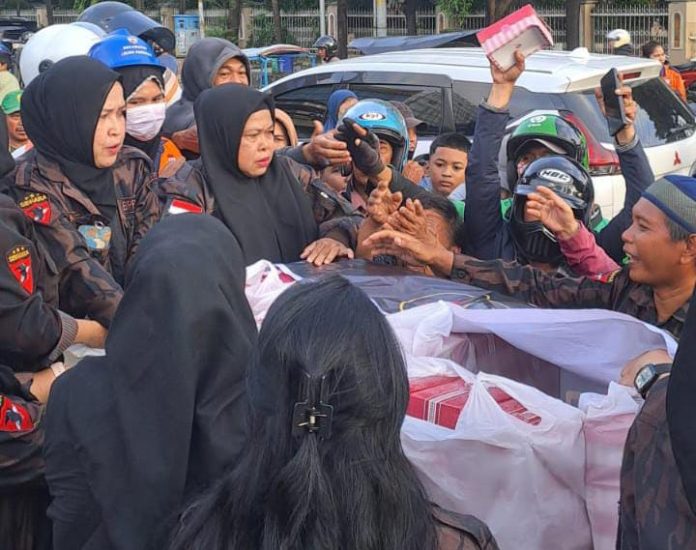 FOTO: Ketua KBPP Polri Resor Makassar, Hj Yuniar Tompo didampingi Sekertaris Handri Salempa serta puluhan pengurus menggelar pembagian takjil kepada para pengguna jalan raya yang melintas di Mako Polrestabes Makassar di Jl. Jenderal Ahmad Yani.