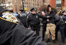 Dua Pria Didakwa Melemparkan Bom Paku ke Kediaman Wali Kota New York Zohran Mamdani FOTO: Aparat kepolisian New York menahan satu dari dua pelaku pelemparan bom paku ke Kediaman Wali Kota New York Zohran Mamdani. (Dok. Charly Triballeau / AFP)