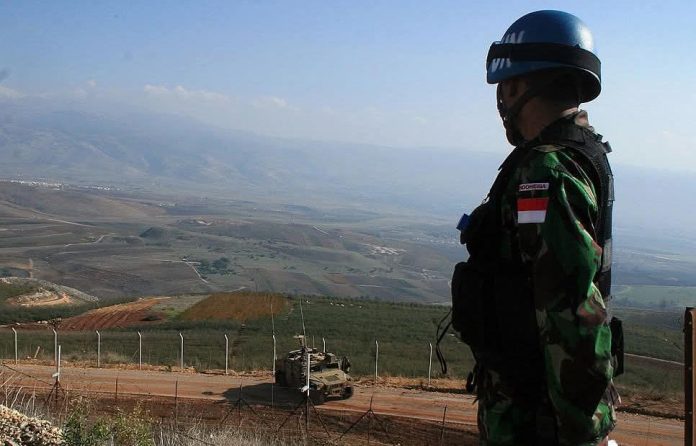 FOTO: Ilustrasi Tentara Nasional Indonesia melaksanakan tugas sebagai pejaga perdamaian dari UNIFIL mengamati suatu area dari titik al-abbad di perbatasan Lebanon dan Israel dekat Hula di Lebanon Selatan pada 8 Juli 2009. (Sumber foto Ali Dia/AFP via Getty Image)