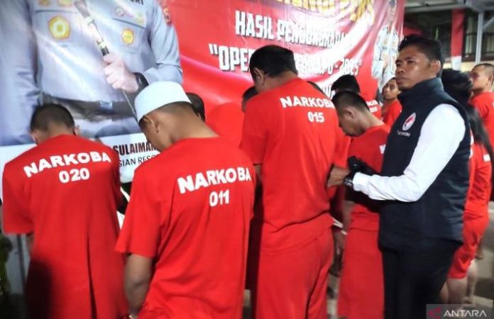 FOTO: Kasat Narkoba Polres Gowa Iptu Firman (kanan) menanyai tersangka pengedar narkoba saat rilis pengungkapan kasus narkoba Operasi Antik Lipu 2025 di Mapolres Gowa, Sulawesi Selatan, Senin (30/6/2025) malam. (Dok. ANTARA/Darwin Fatir)