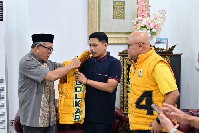 FOTO: Ilham Arief Sirajuddin saat memberikan rompi partai golkar ke Islam Iskandar Wabup Jeneponto yang didampingi Ketua Harian DPD II Golkar Jeneponto Ikram Ishak Iskandar Karaeng Nyau. (ist)