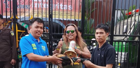 Demo Kasus Dana Hibah KONI: Tidak Bakar Ban, Maulan Bawakan Kejari Makassar Ayam Jantan FOTO: Kepala Seksi (Kasi) Intelijen Kejari Makassar, Sulfikar, SH., MH., saat menerima "Ayam Jantan" dari perwakilan pengunjuk rasa Maulana di pelataran Kantor Kejaksaan Negeri Makassar, Jalan Amanagappa No. 15, Kelurahan Baru, Kecamatan Ujung Pandang, Kota Makassar, Sulawesi Selatan. Jumat (24/7/2026). (ist)