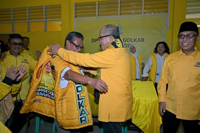 FOTO: Ketua DPD I Partai Golkar Sulsel, Ilham Arief Sirajuddin (IAS) saat memasangkan rompi partai golkar ke mantan Mantan ketua PPP Kota Palopo, Haidir Basir. Kamis (13/8/2026).