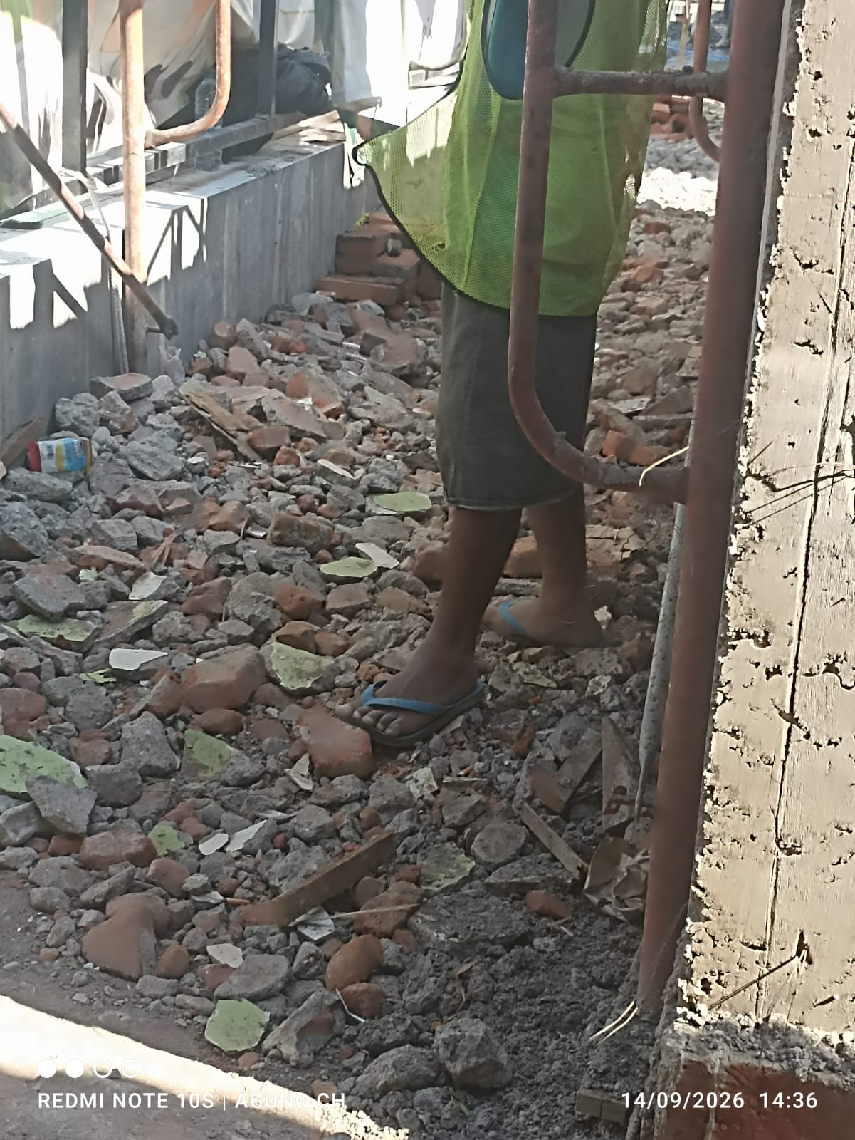 Seorang Pekerja Proyek Revitalisasi SDN Suko 1 Sidoarjo Mengenakkan Sandal Japit Saat Beraktivitas 