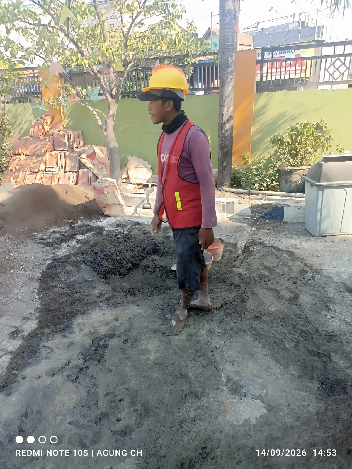 Seorang Pekerja Proyek Revitalisasi SDN Suko 1 Sidoarjo Tak Menggunakan Alas Kaki Saat Beraktivitas  